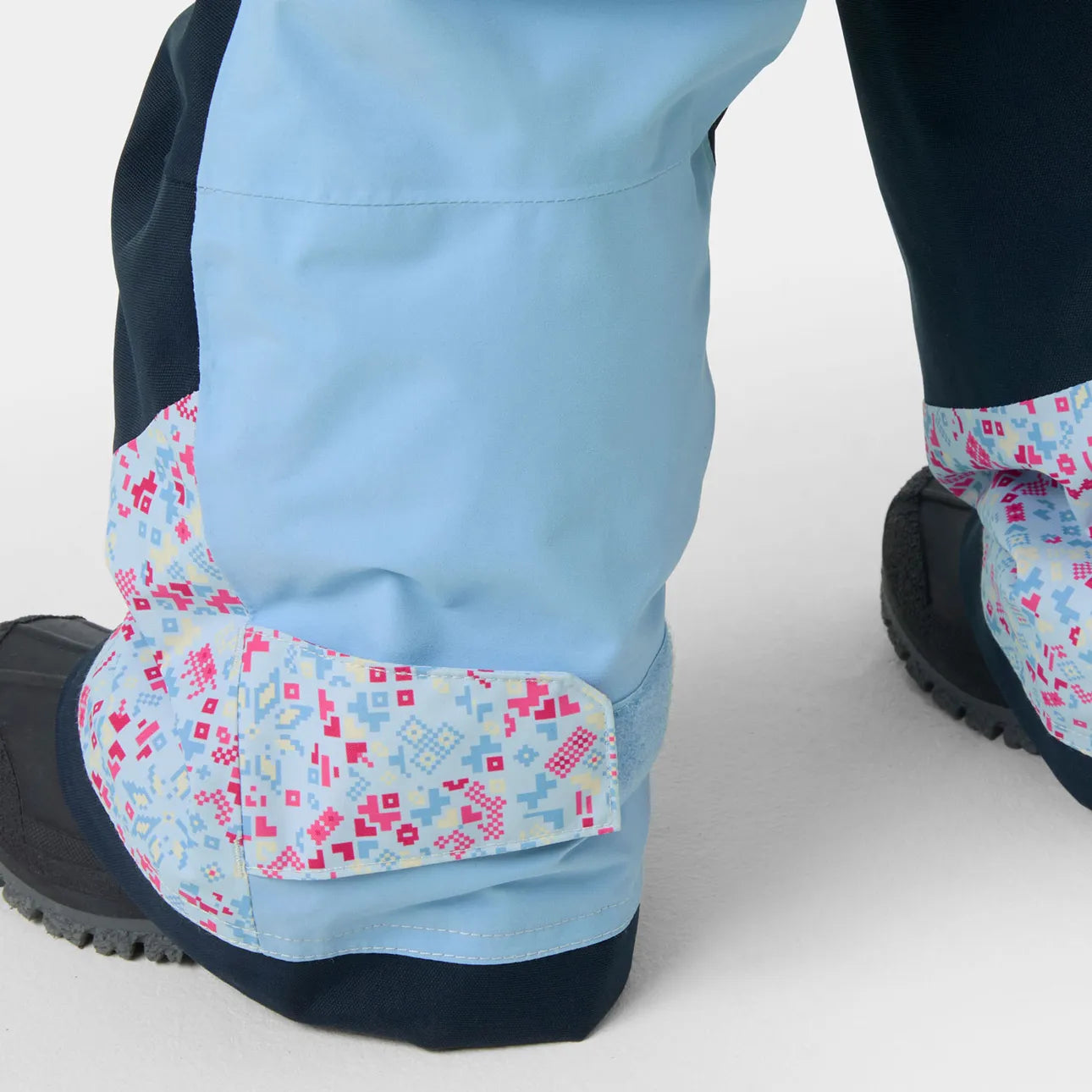 Salopette de neige Rider - Helly Hansen bleu clair avec motifs géométriques roses et bleus vue en détail portée