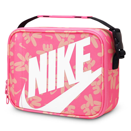 Sac à lunch rectangulaire rose avec motifs beige, grand logo NIKE blanc, poignée noire, vue de côté légèrement inclinée.