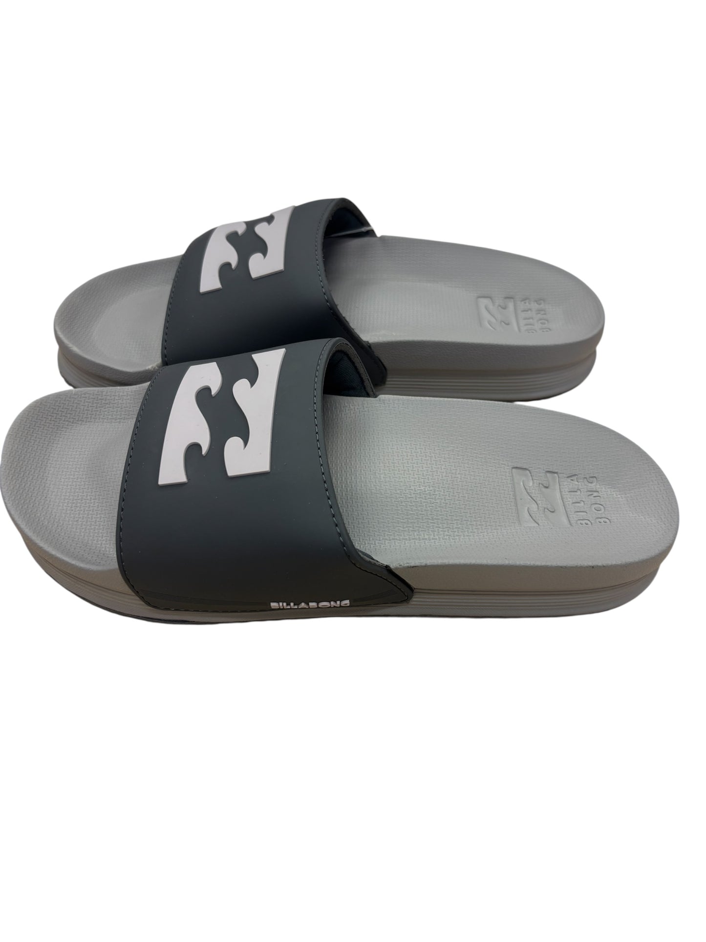 Sandales pour homme - Billabong, bride noire avec logo blanc, semelle grise, style slide, vue latérale portée.