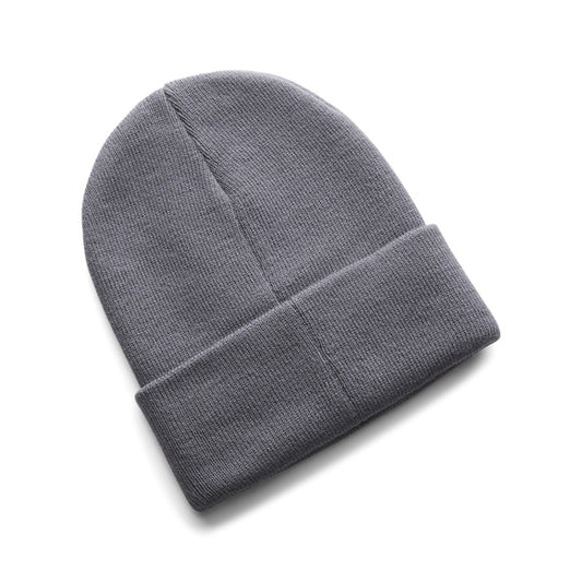 Tuque d'hiver - Under Armour en tricot gris, style classique avec revers, vue de dessus sur fond blanc.