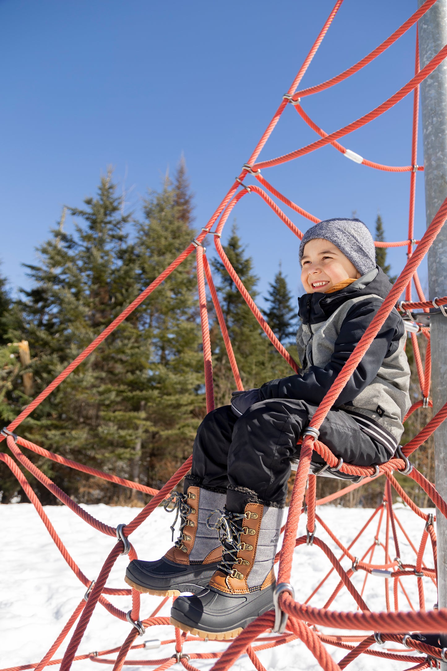 Bottes d'hiver Energy - Acton en cuir synthétique et nylon gris et marron, garçon, vues de côté assis sur structure de jeu rouge.