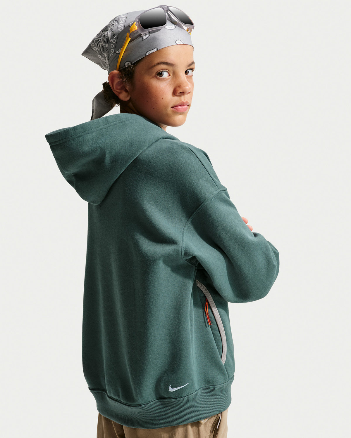 Hoodie ACG - Nike vert foncé à capuche porté par un jeune modèle en vue de dos trois quarts