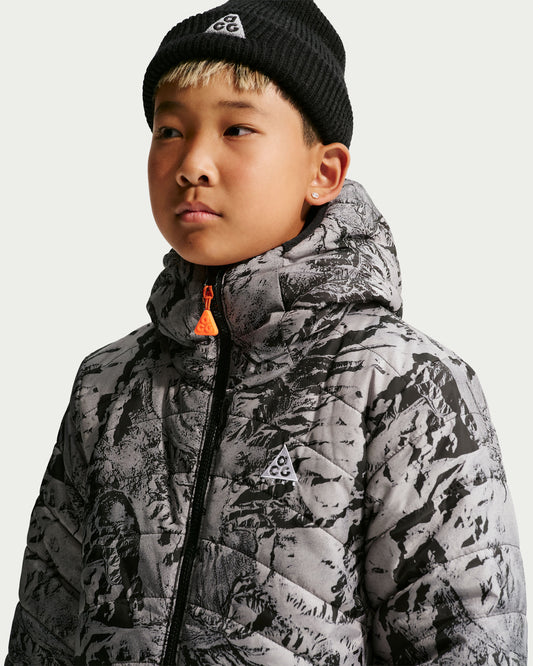 Manteau Mi-Saison ACG Reversible - Nike gris et noir à motifs graphiques porté par un garçon vue de face