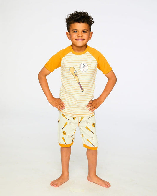 Pyjama deux-pièces - Deux Par Deux en coton biologique, manches courtes jaunes, motifs balle et batte, garçon, vue de face portée.