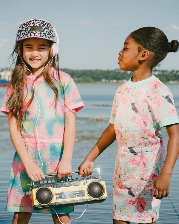 Casquette - Deux Par Deux noire à imprimé animal coloré, visière plate, portée par fille, vue de face en extérieur au bord de l'eau