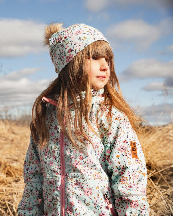 Tuque Mi-Saison - Deux Par Deux fleurie rose et beige avec pompon amovible, en polyester et élasthanne, portée par enfant, vue de profil.