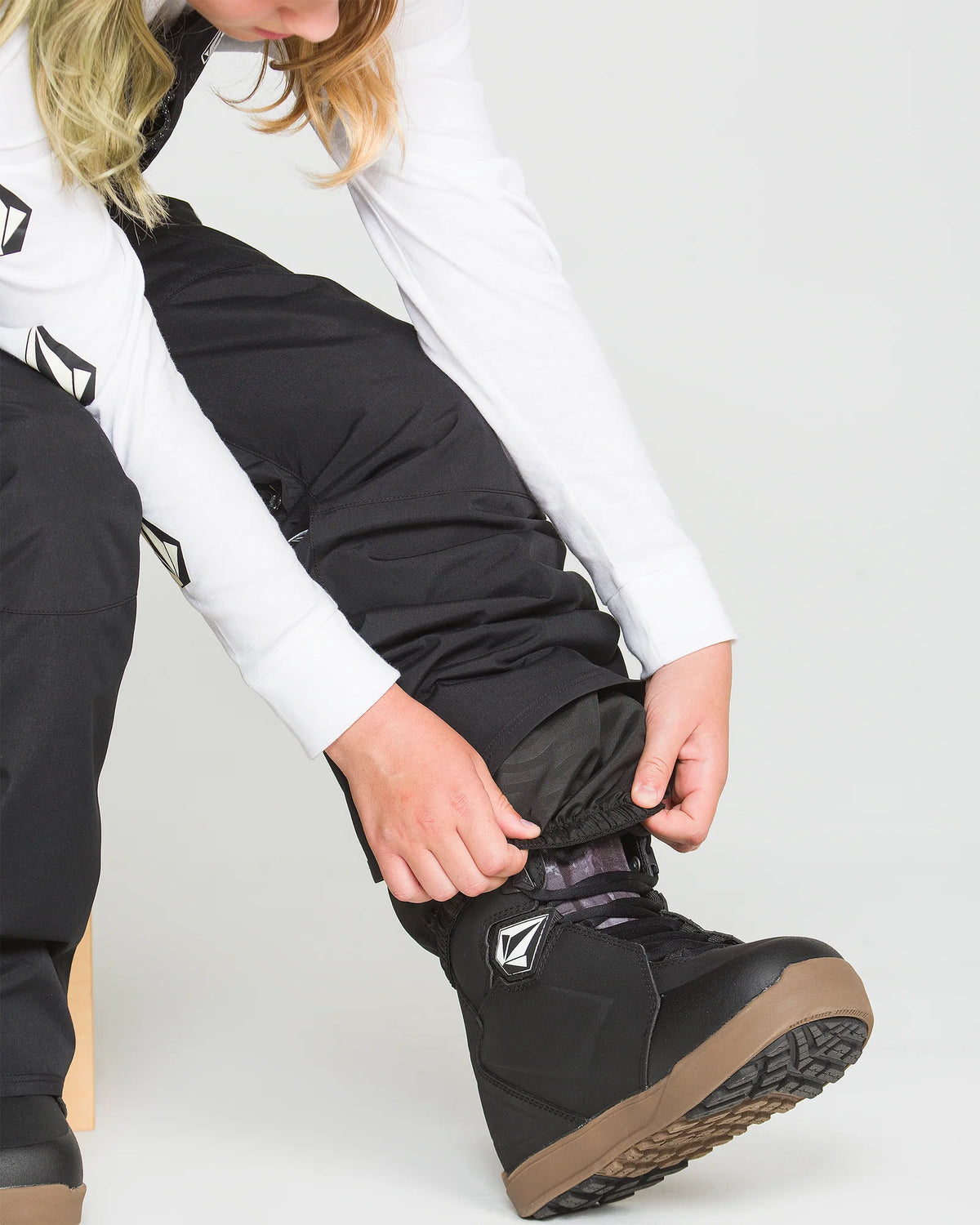 Salopette de neige Barkley Ins Bib - Volcom noire portée en détail avec botte de snowboard noire à semelle brune