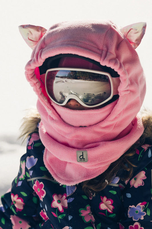 Grande cagoule en polaire pour casque de ski - Deux Par Deux, rose clair avec oreilles, portée par enfant fille avec lunettes de ski, vue de face.