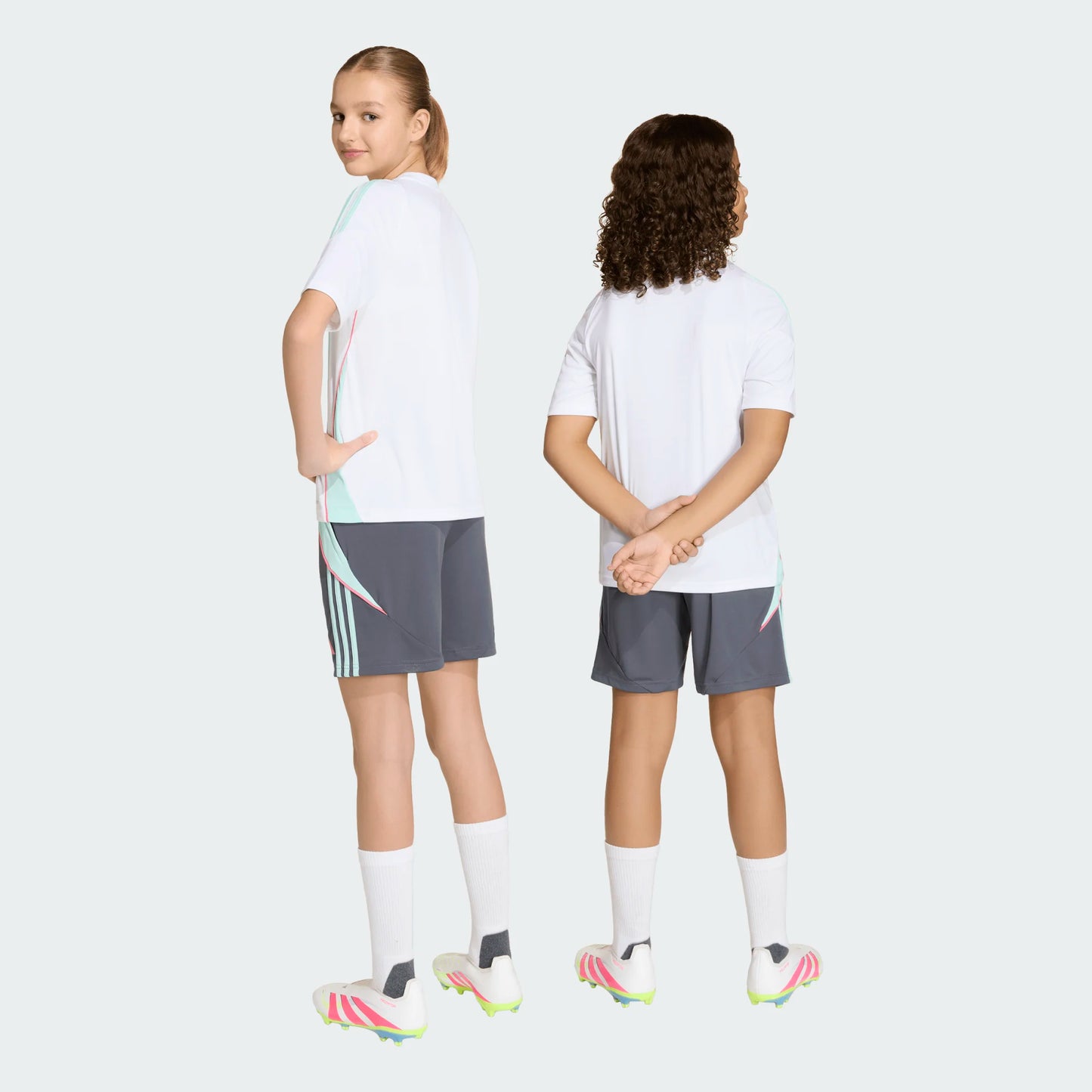 Short Messi - Adidas en polyester gris ajustable, porté par deux enfants de dos et de face, avec chaussettes blanches et chaussures de foot.