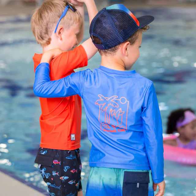 Casquette - Nanö bleu marine et orange portée par enfant, vue de dos au bord de la piscine, style filet respirant