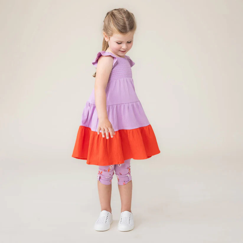 Robe - Nanö portée par une enfant vue de côté en image 2, robe à volants et jupe évasée bicolore.