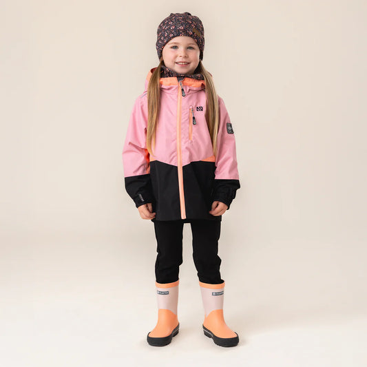 Fille portant un Manteau Mi-Saison - Nanö rose et noir avec capuchon, bottes et bonnet, sur fond neutre.