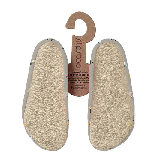 Semelles antidérapantes Slip Stop beige avec motifs colorés, tissu souple, taille enfant, vue de dessous.