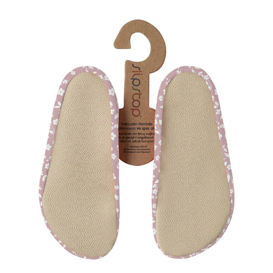 Slip Stop semelles antidérapantes beige avec bordure rose à motifs blancs, détail, vue de dessus.