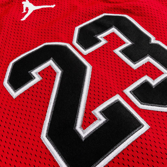 Détail du tissu en polyester rouge avec numéro noir et blanc, camisole - Jordan, vue en gros plan.