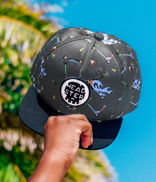 Casquette - Headtser Kids noire avec motifs colorés graphiques, logo rond blanc et noir, pour enfant, vue de face portée main