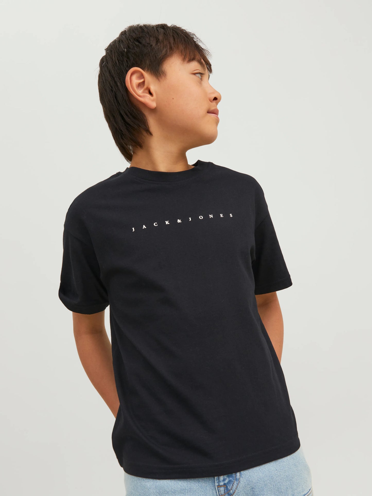 T-Shirt - Jack & Jones en coton noir avec logo blanc, porté par garçon, vue de face avec regard de côté