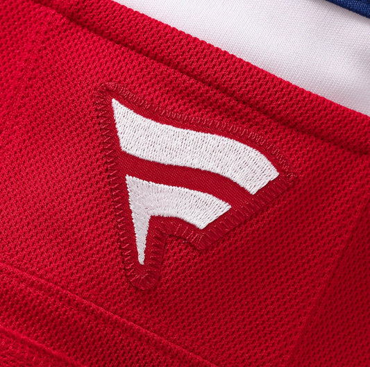 Détail en gros plan du tissu rouge en maille avec logo blanc brodé sur le Jersey de hockey Canadiens - Hutson.