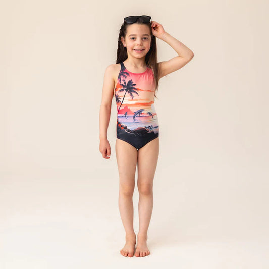 Maillot de bain - Nanö une pièce rose avec dessin de palmiers et dauphins, pour enfant fille, vue de face porté sur mannequin.