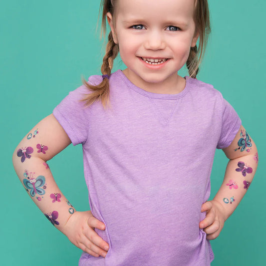 Tatouages temporaires Pico Tatoo - Les jolis papillons, papillons violets et bleus, sur bras de fillette, vue de face.
