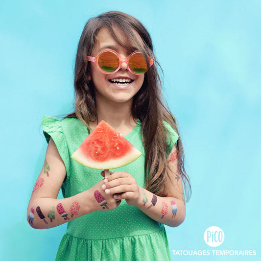 Pico Tatoo - Les pops colorés tatouages temporaires multicolores sur bras fille enfant, vue de face, tenue verte, lunettes roses
