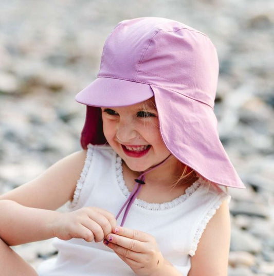 Enfant souriant portant un Chapeau U.V - Calikds rose, réglable avec protection couvrant la nuque, photo portrait galerie 2.