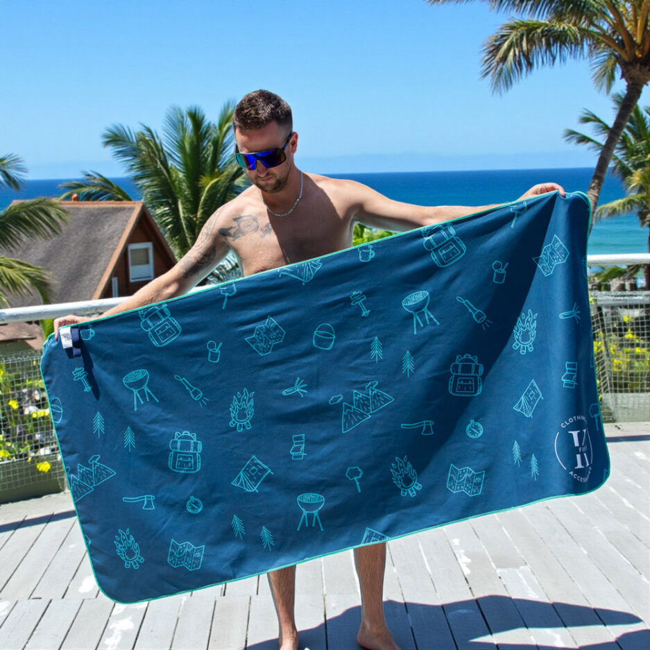 Serviette de plage - Libre comme l’air bleu marine à motifs camping verts, microfibre, portée par homme, vue de face extérieure.