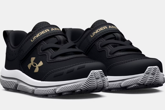 Espadrilles UA Assert 10 AC - Under Armour noires avec détails dorés, tige mesh, scratch, semelle blanche, vue de profil avant enfant.