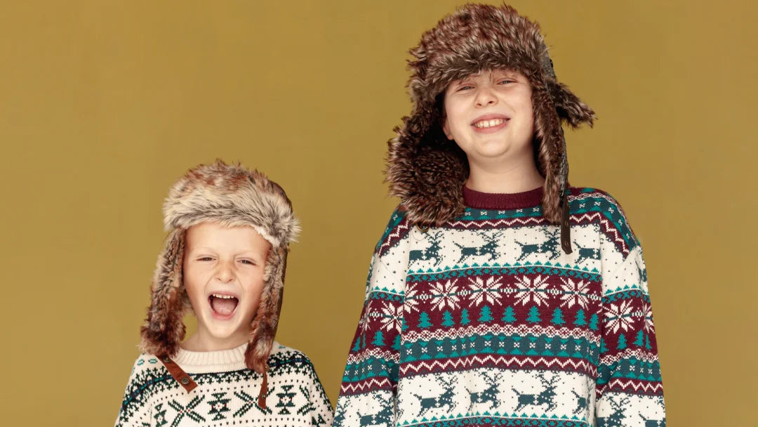 Deux enfants en vêtements d'hiver et bonnets, prêts pour jouer dans la neige.