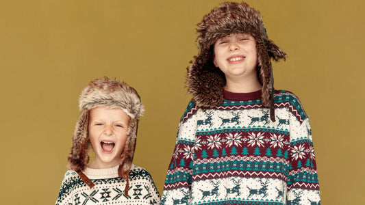 Deux enfants en vêtements d'hiver et bonnets, prêts pour jouer dans la neige.