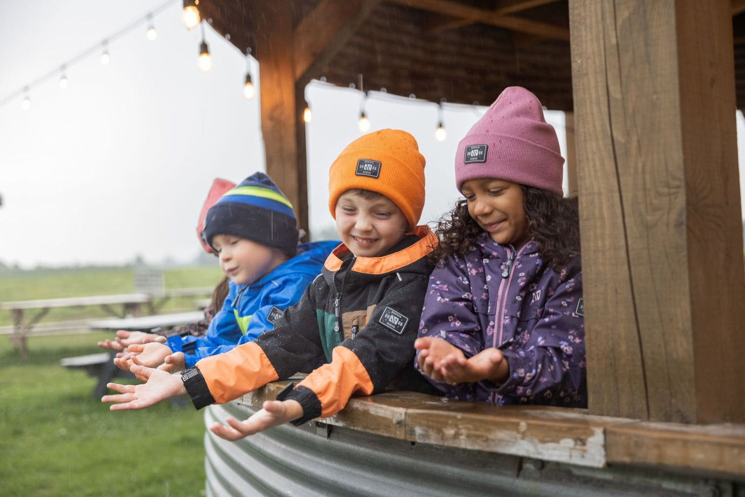 Groupe d’enfants actifs à l’extérieur, vêtus de manteaux mi-saison pour enfants conçus pour le printemps et l’automne.