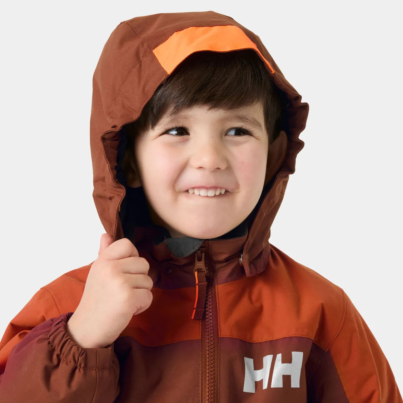 Habit de neige Rider 3.0 Insulated Snow Suit - Helly Hansen brun et orange pour garçon porté avec capuchon relevé vue de face