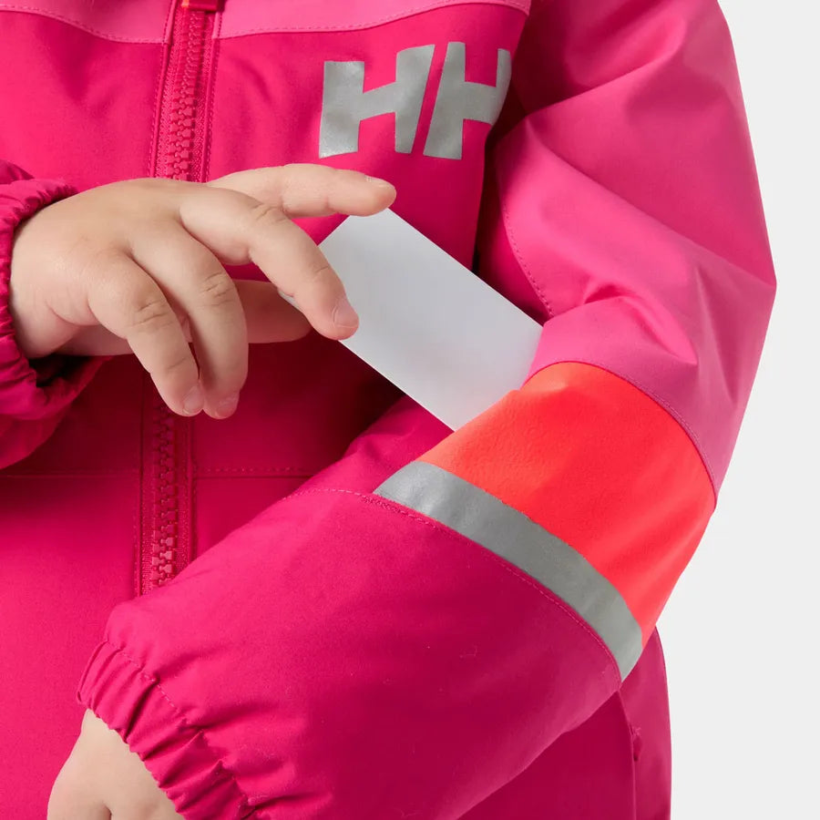 Manteau d'hiver Rider - Helly Hansen pour enfant, rose et corail avec bande réfléchissante grise, détail de la manche et main insérant un objet, vue rapprochée.