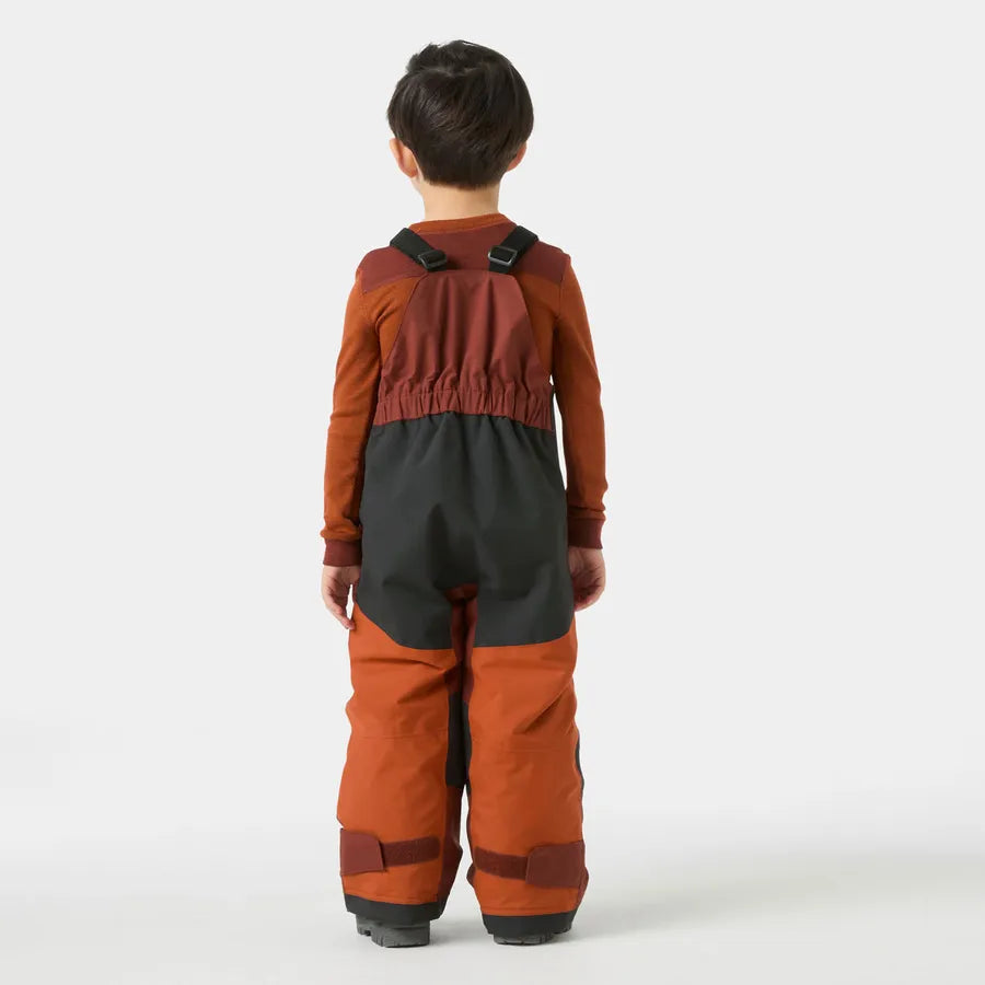 Salopette de neige Rider - Helly Hansen bicolore marron et noir en tissu technique, portée par un enfant, vue de dos.