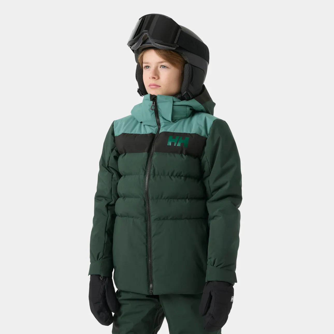 Enfant portant une tenue de ski vert foncé avec veste matelassée et pantalon assorti casque noir gants noirs vue de face