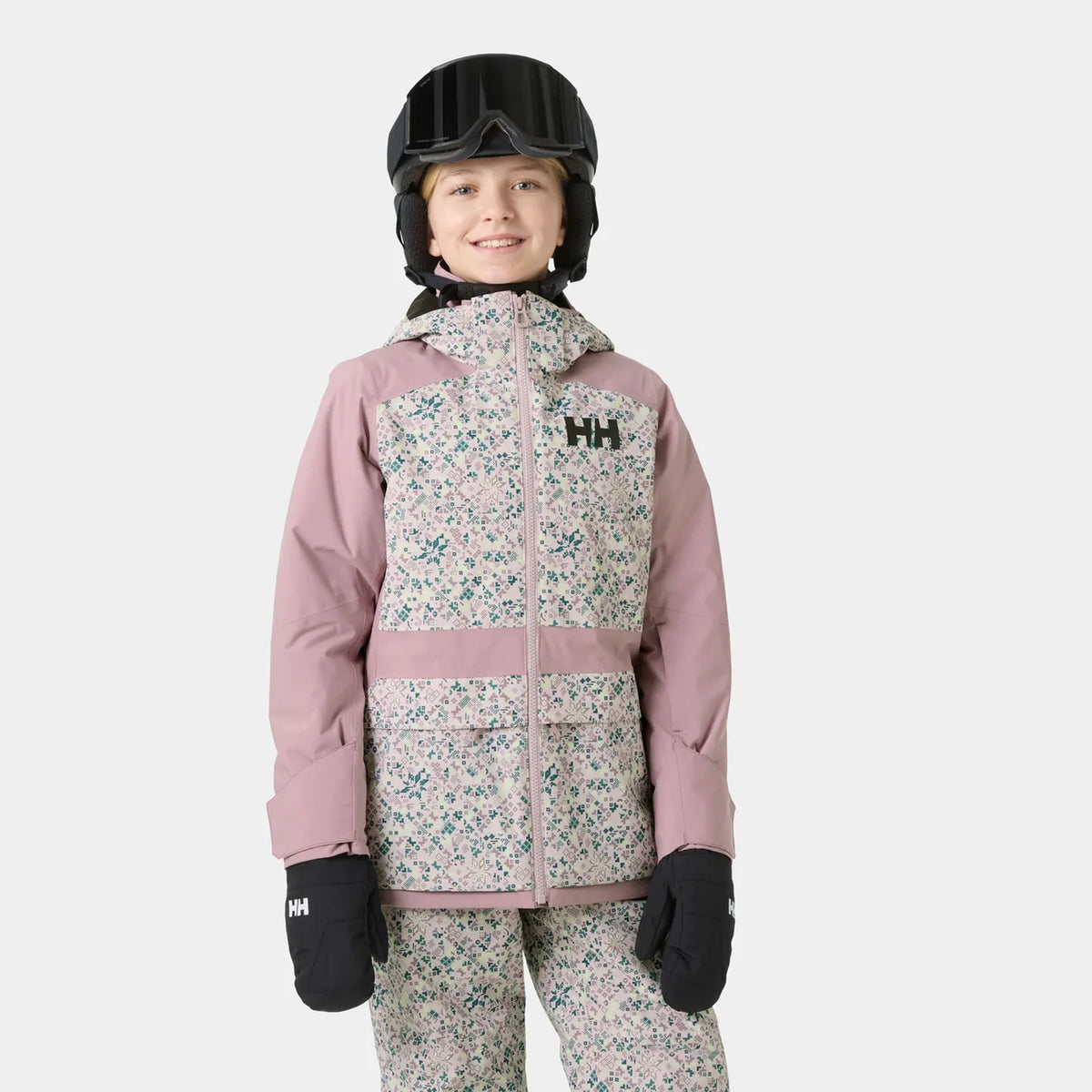 Manteau d'hiver Stellar Jacket 2.0 - Helly Hanse rose à motifs floraux porté par une enfant avec casque et moufles vue de face