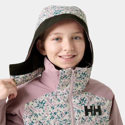 Manteau d'hiver Stellar Jacket 2.0 - Helly Hanse rose pâle et crème à motif géométrique, à capuche, porté par une fille de face