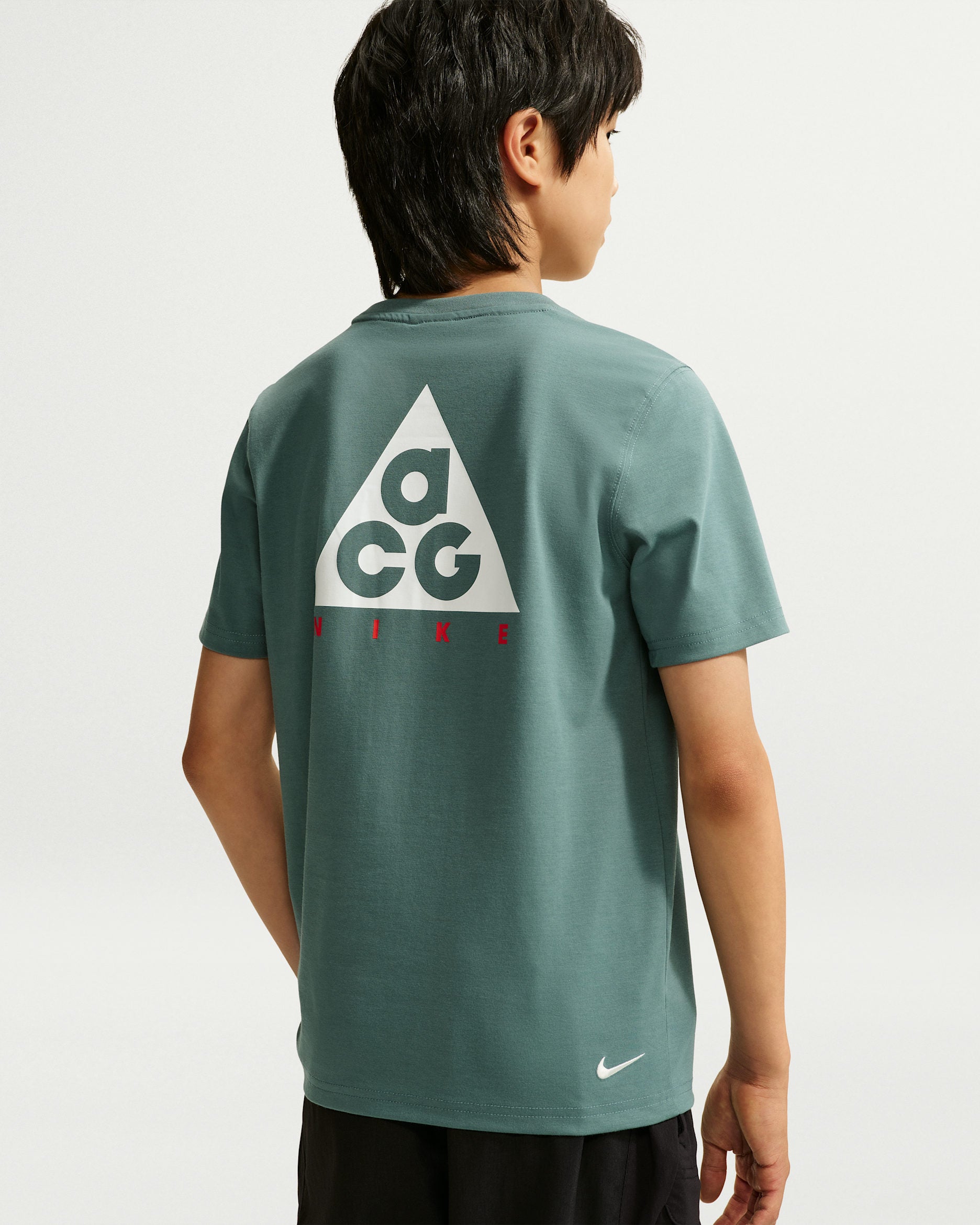 T-Shirt Hbr Acc - Nike vert à manches courtes avec logo graphique blanc et rouge au dos porté par un garçon vue de dos