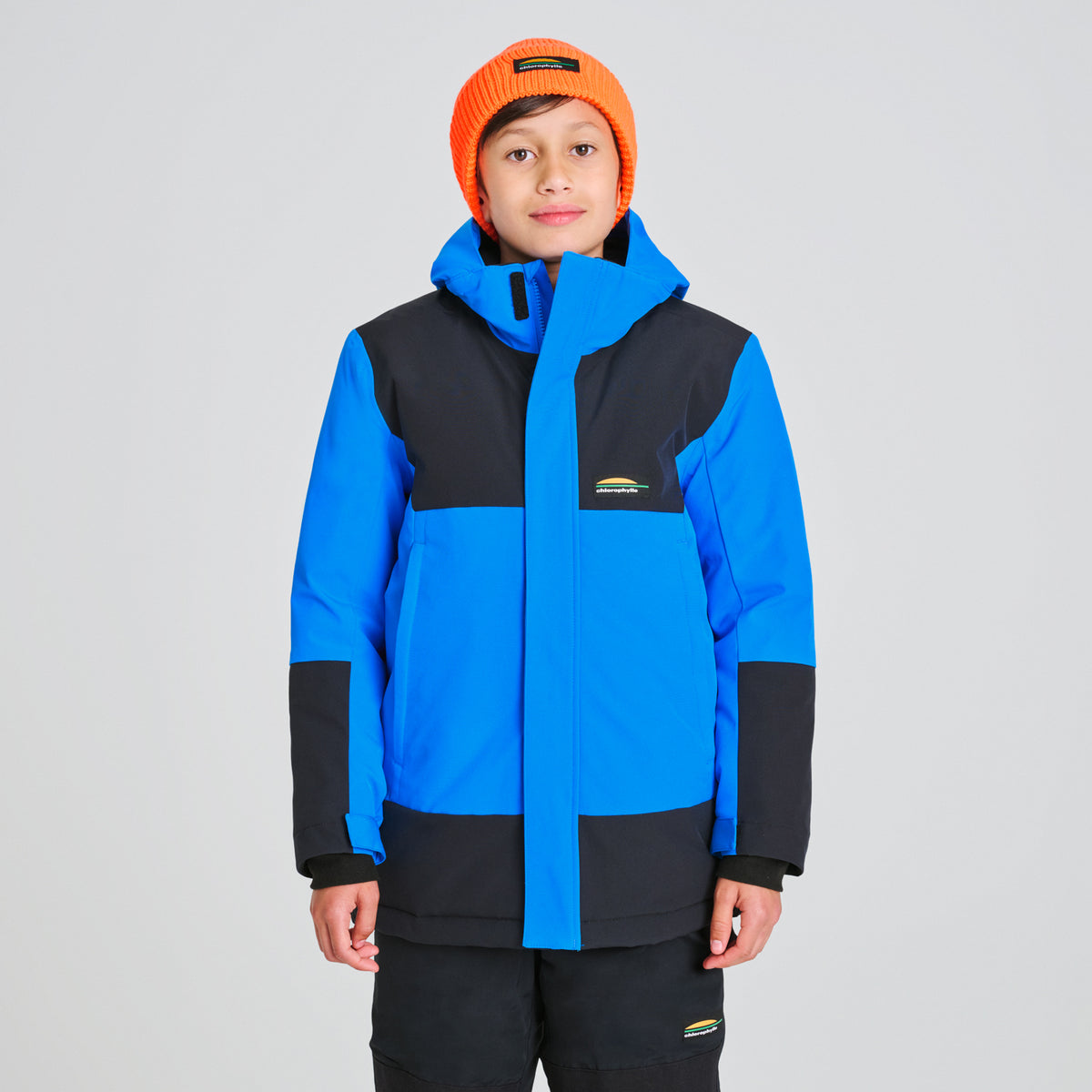 Manteau D'hiver Nordic - Chlorophylle bleu et noir pour garçon enfant portant un bonnet orange vue de face