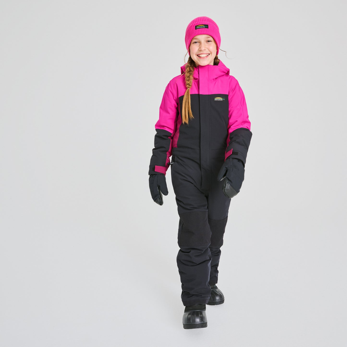 Habit de neige 1 Pièce - Chlorophylle rose vif et noir en matière isolante, pour enfant fille, porté de face avec bonnet et moufles assortis.