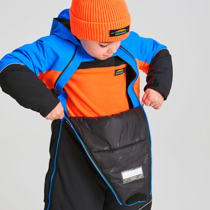 Enfant portant un Habit de neige 1 pièce - Chlorophylle bleu, noir et orange, en train de zipper la combinaison, vue de face avec capuche et bonnet orange.