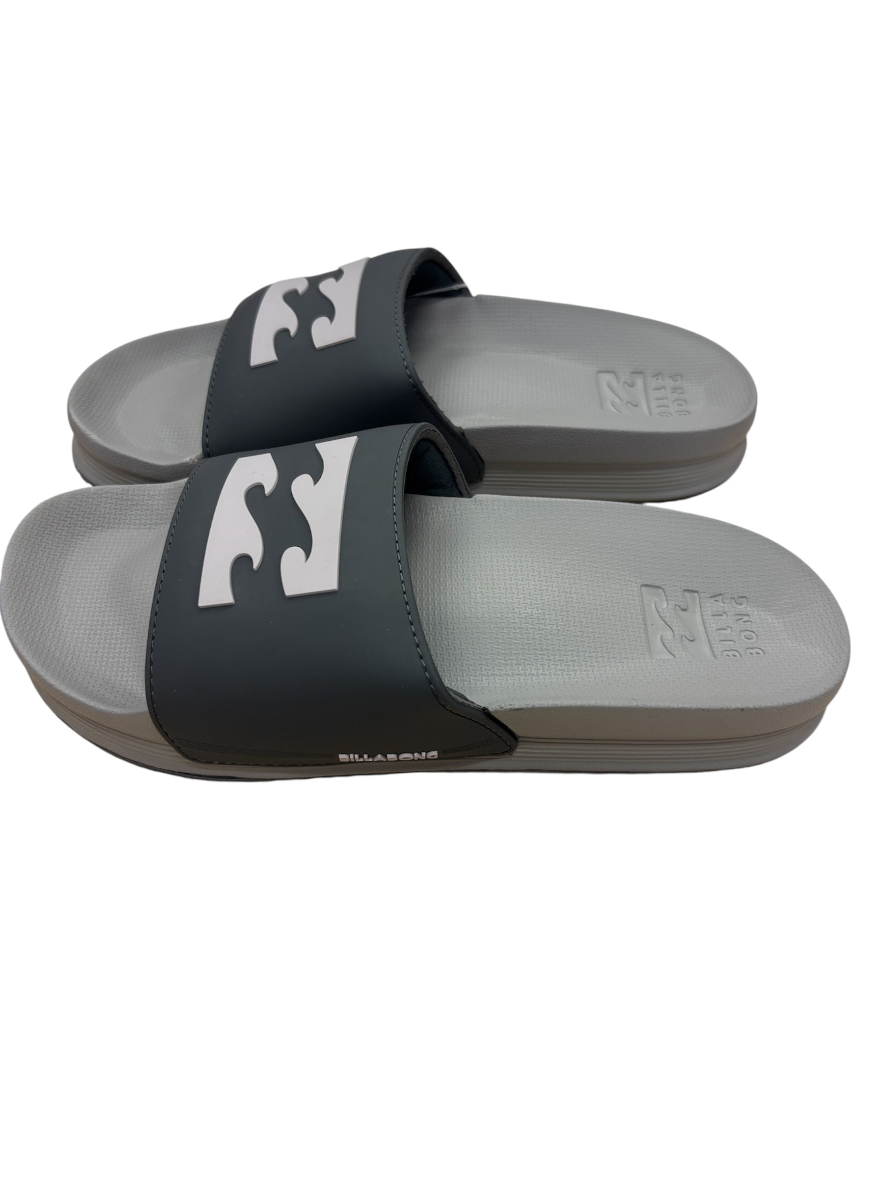 Sandales pour homme - Billabong, bride noire avec logo blanc, semelle grise, style slide, vue latérale portée.