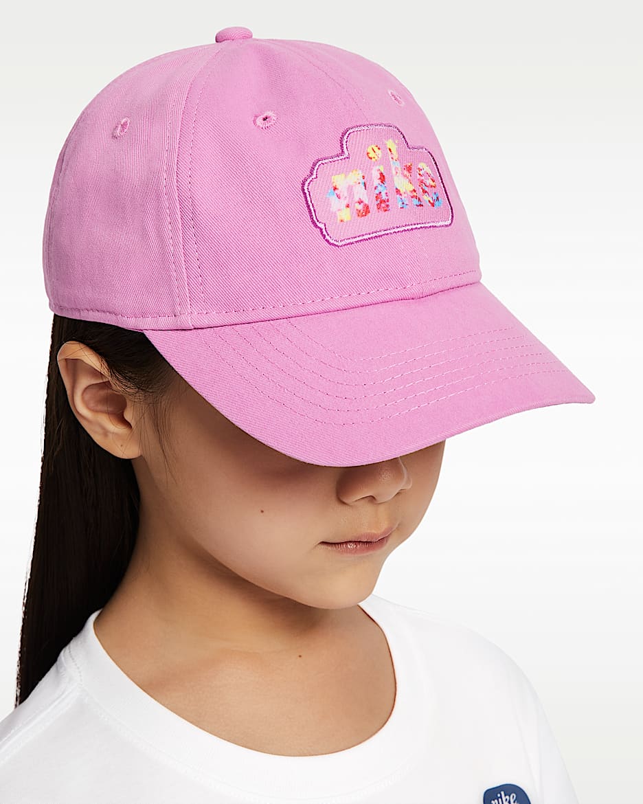 Casquette - Nike rose en sergé de coton brossé, logo coloré à l’avant, portée par une enfant, vue de trois quarts face.
