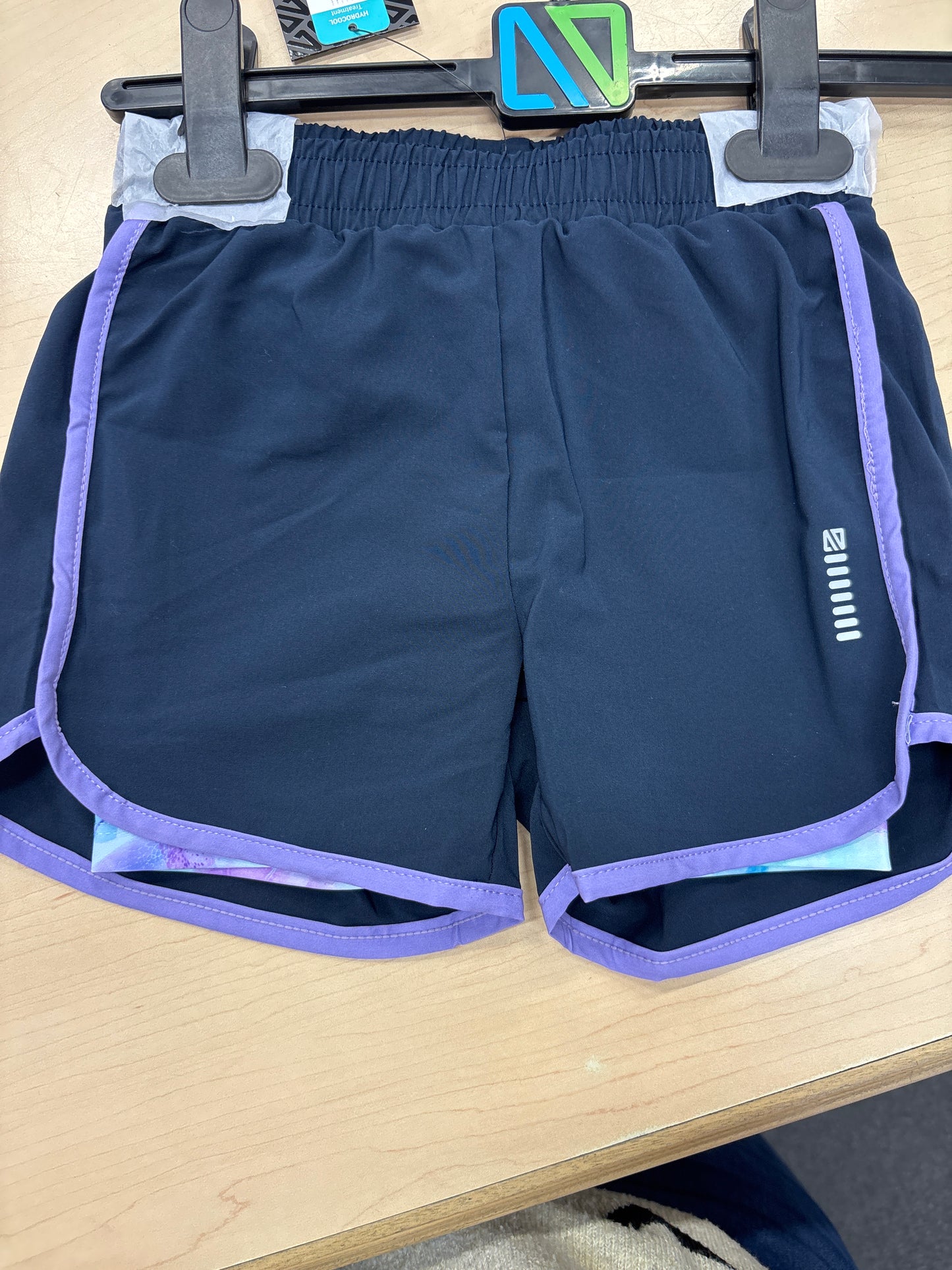 Short - Nanö bleu marine avec bordure violette, taille élastique, tissu léger, pour enfant, vue face, suspendu sur cintre.