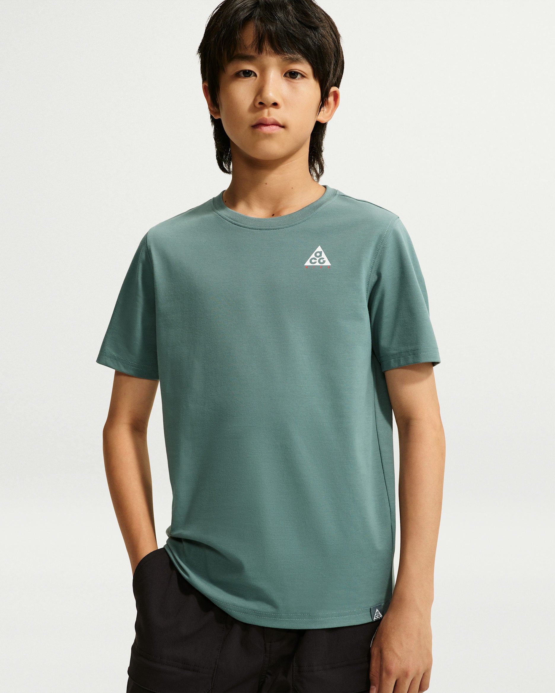 T-Shirt Hbr Acc - Nike vert sauge à manches courtes porté par un garçon vue de face avec petit logo sur la poitrine