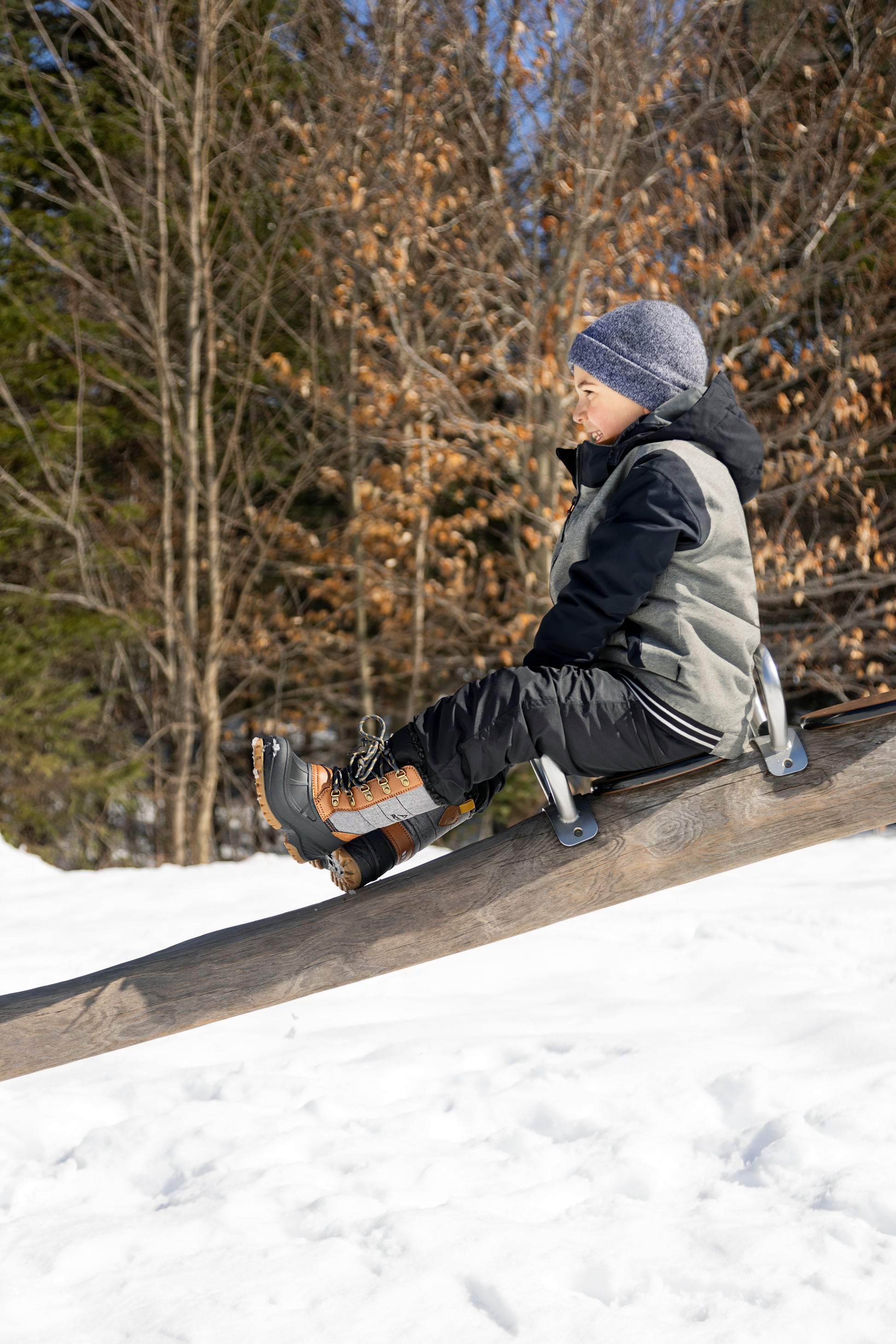 Bottes d'hiver Energy - Acton marron et noires, cuir synthétique, vue de profil porté par enfant garçon en plein air hiver