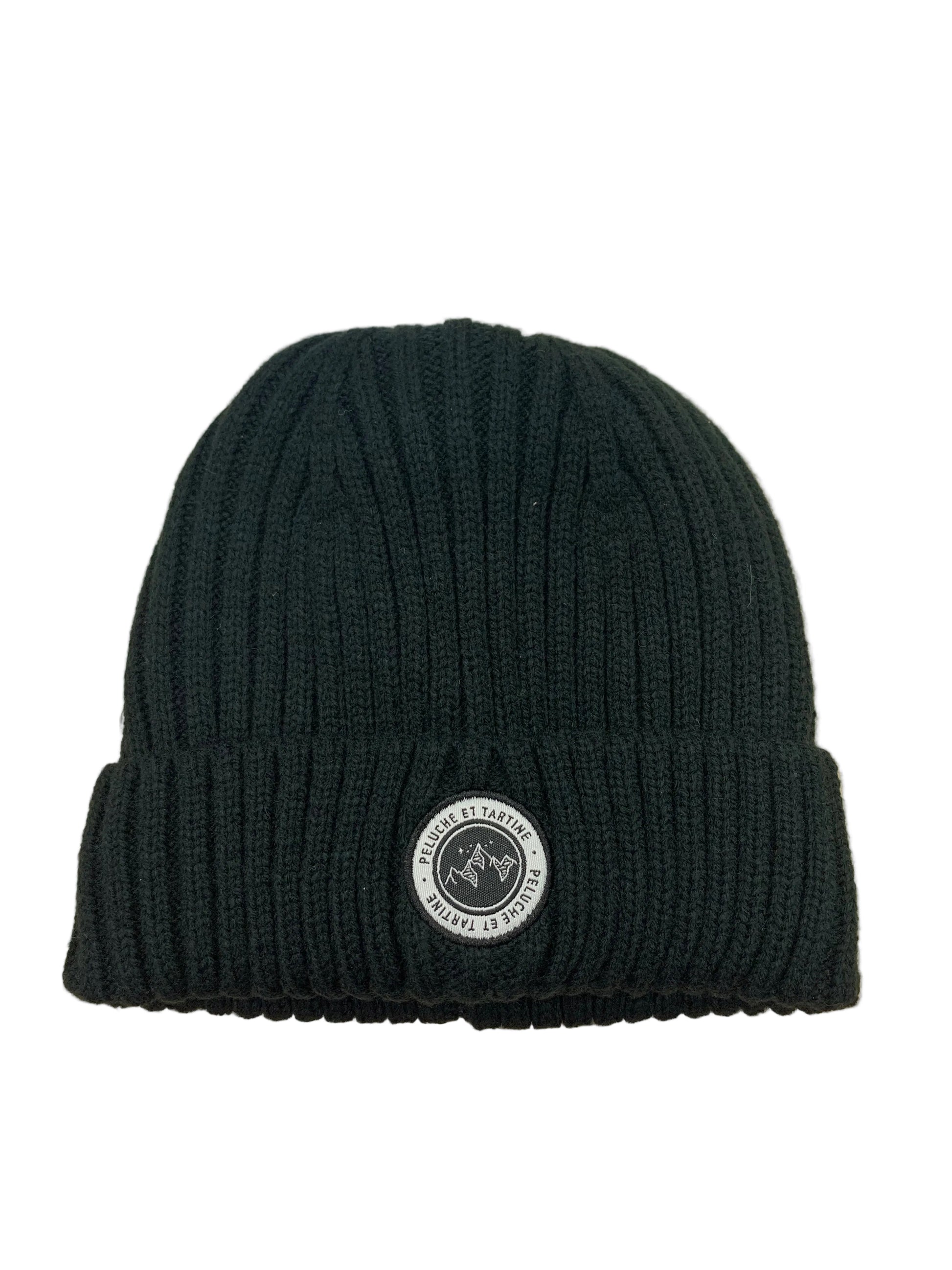 Tuque d'hiver - Nanö en tricot côtelé noir avec écusson rond blanc, pour enfant, vue de face.