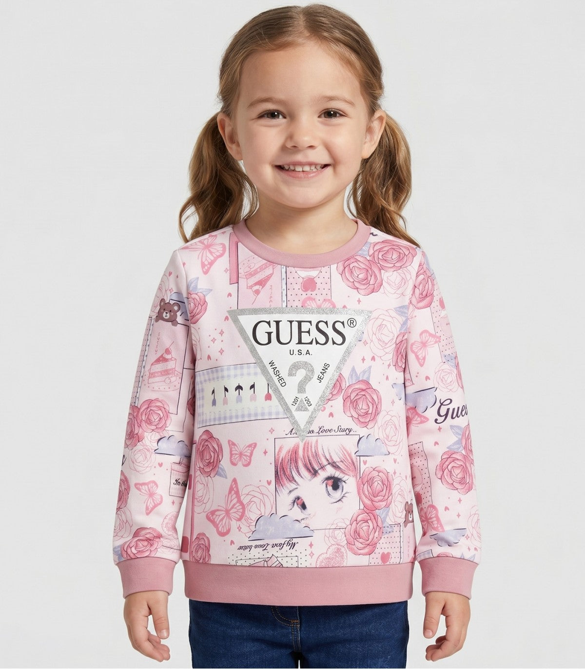 Chandail - Guess rose clair avec motifs de papillons, fleurs et personnages dessinés, pour fille enfant, vue de face porté sur mannequin.