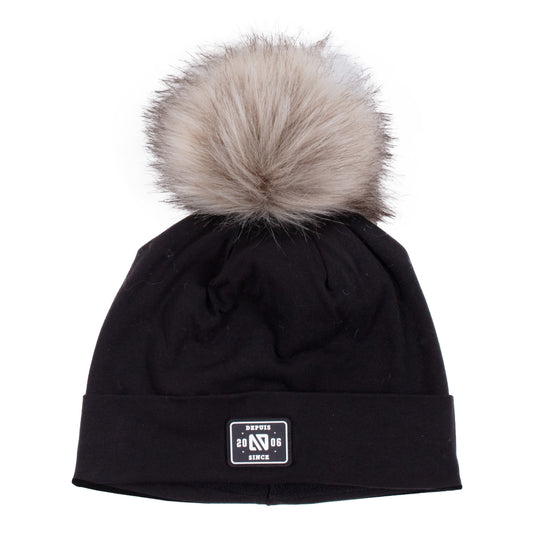 Tuque Mi-Saison noire avec pompon en fausse fourrure beige, en tissu doux, vue de face adaptée pour enfant.