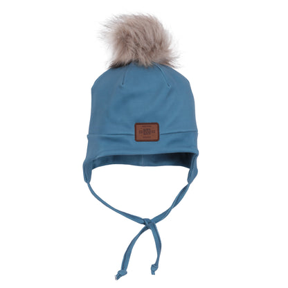 Tuque Mi-Saison - Nanö bleu avec pompon fourrure beige, liens à nouer sous le menton, style mi-saison pour enfant, vue de face.